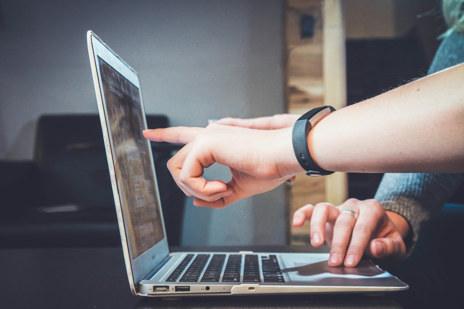 Close-up of professionals collaborating on a laptop